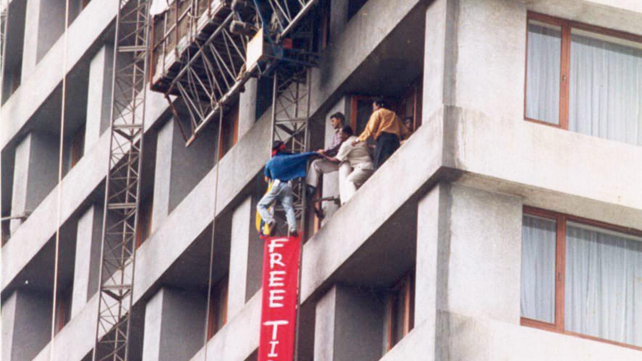 Tenzin climbs up fourteen floors of  The Oberoi (now Hilton) and hangs a  banner reading Free Tibet: in 2002. 