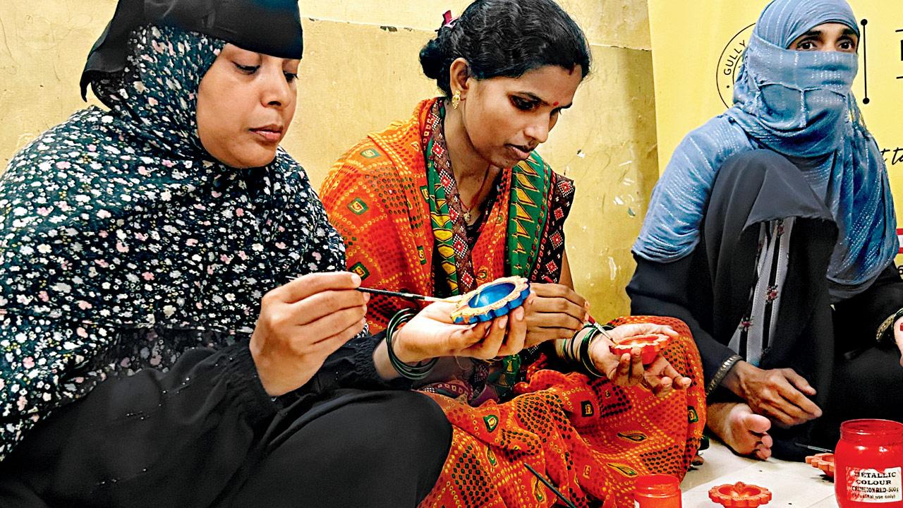 Women paint diyas at the centre