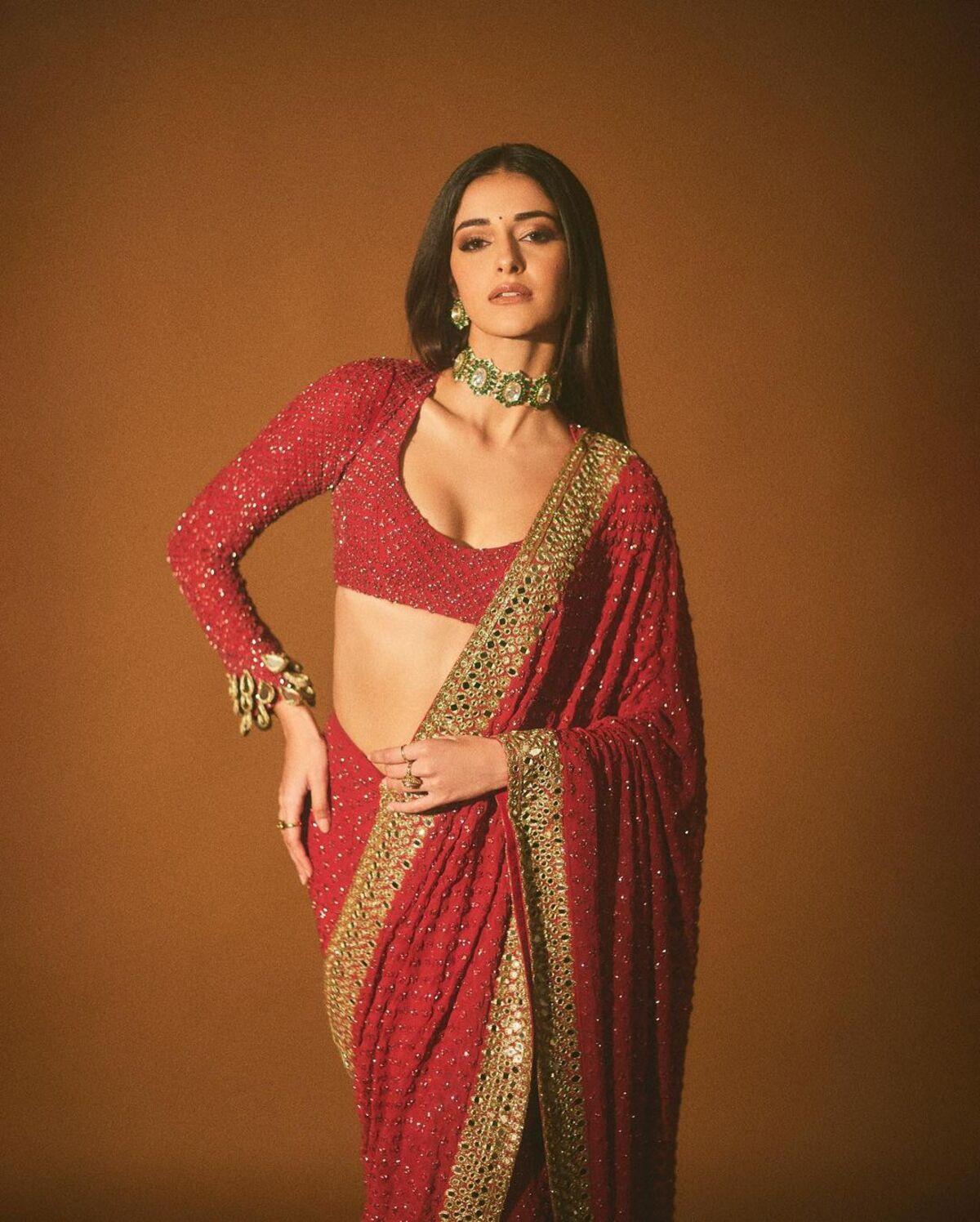 Ananya Panday opted for a scoop neck blouse with a red and golden shimmery saree. The saree featured a golden layered border.