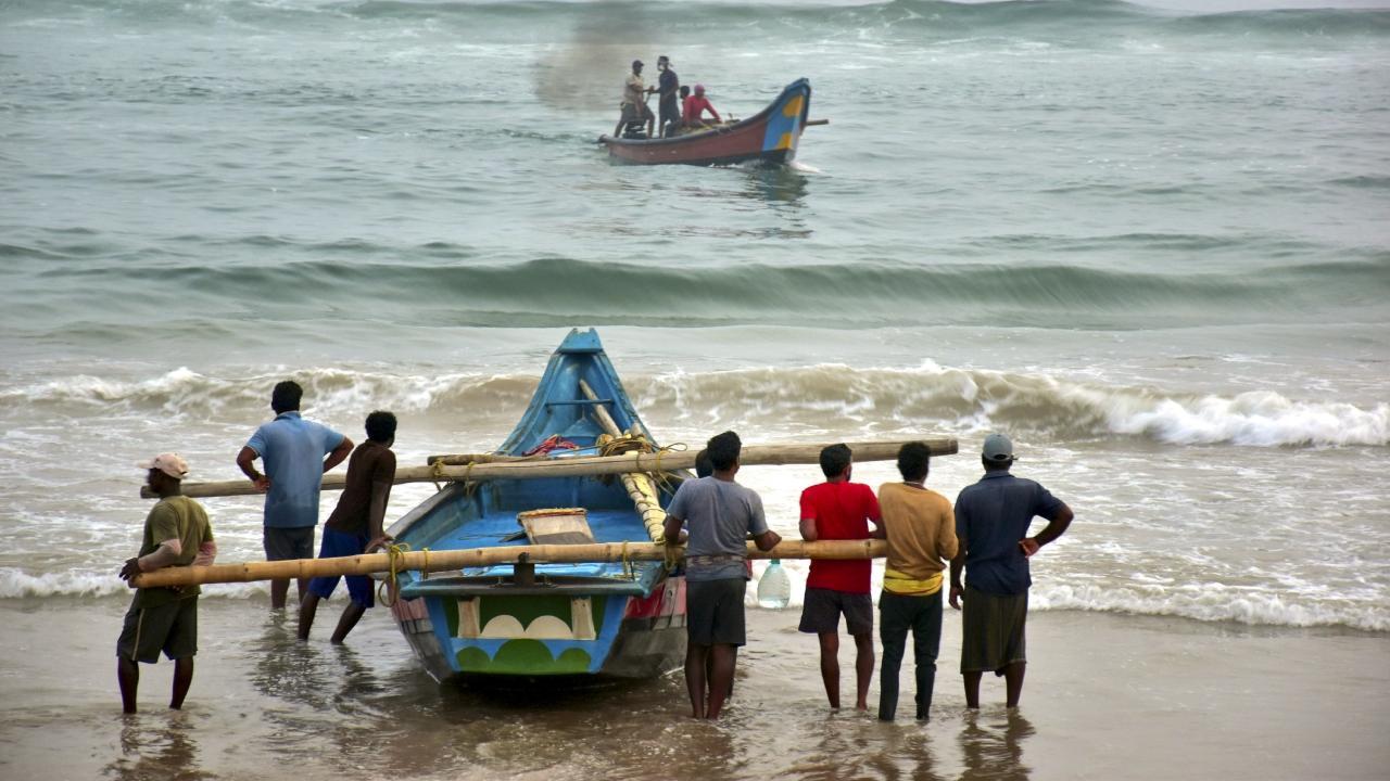 Fishermen shift their boats in preparations for Cyclone Dana, in Puri. Pics/PTI
