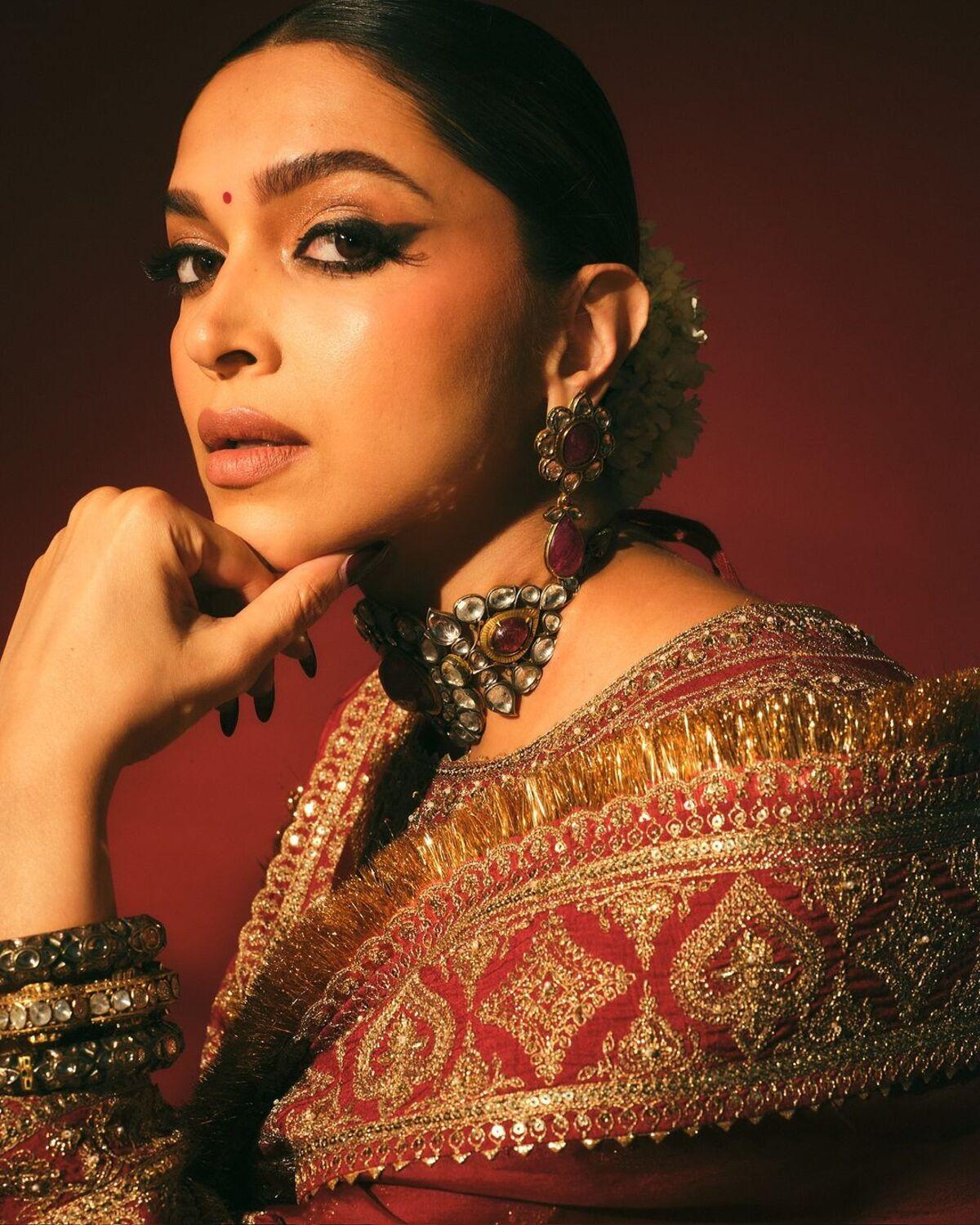 She completed the look with a kundan and maroon choker, heavy earrings and bronze-look bracelets.  She looks breathtaking in this fit!