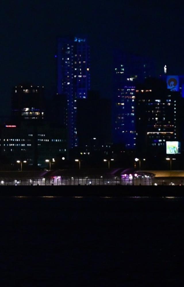 Prominent city buildings, landmarks, streets and homes are lit with vibrant decorations