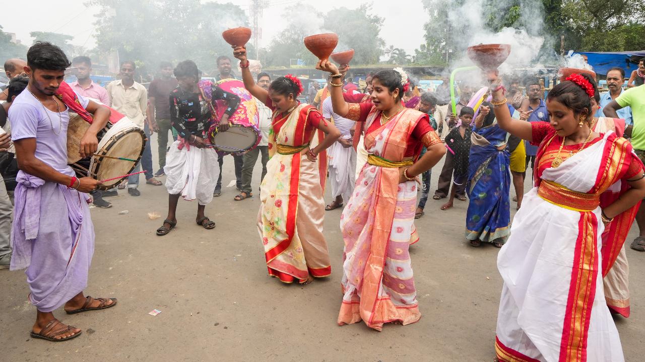 Devotees perform ‘Dhunuchi Nach' dance during a procession for ‘visarjan’ (idol immersion) on the banks of the Ganga river marking the end of the Durga Puja festival, in Kolkata