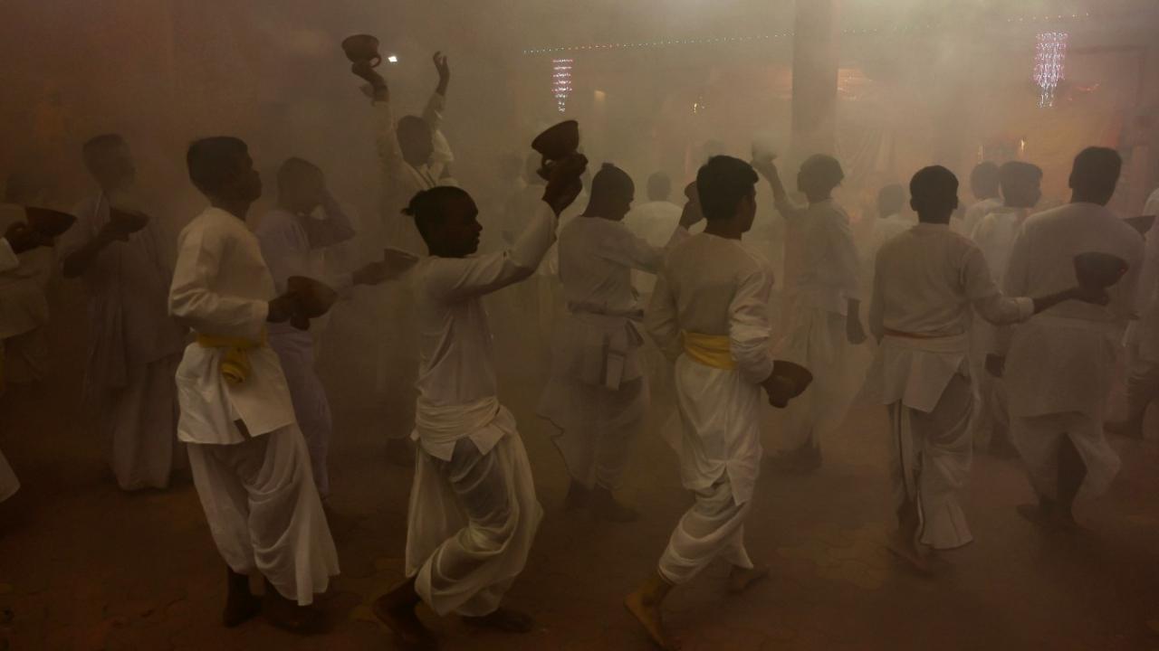 Devotees perform 'Dhunuchi Nach' dance in front of an idol of Goddess Durga during 'Arti' ritual amid the Durga Puja festival in Varanasi 