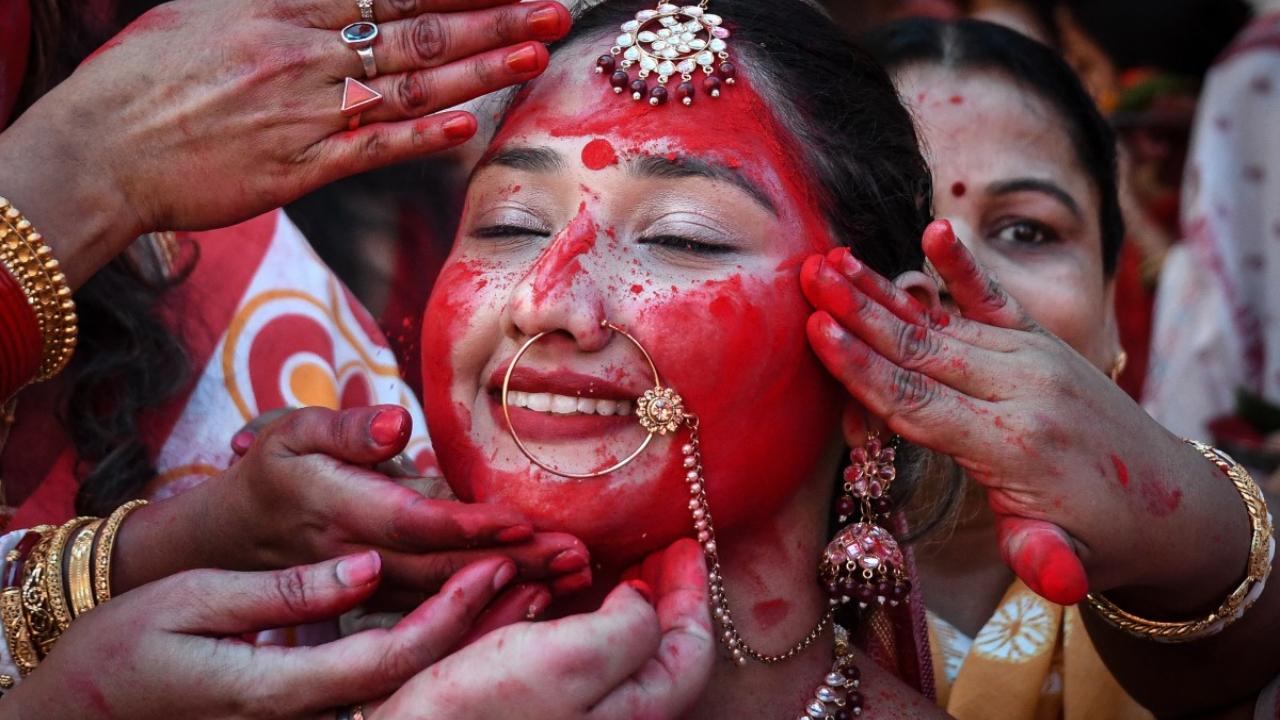 Devotees take part in a ritual 'Sindoor Khela' wherein married women anoint each other with vermilion powder ahead of the immersion of the idol of Goddess Durga during Durga Puja festival in Chandigarh 