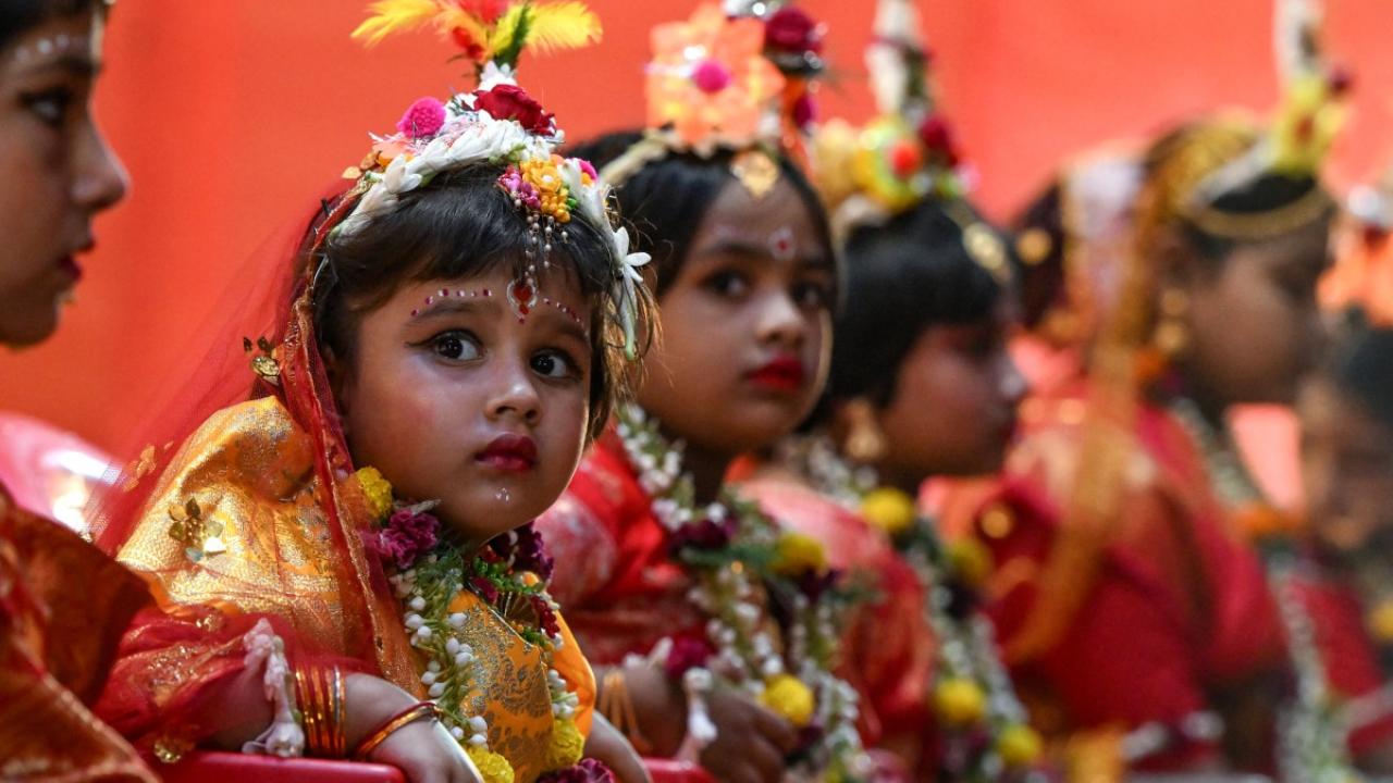 Young girls dressed as Goddess Durga sit near the deity's idol during the traditional 'Kumari Puja' as a part of the Durga Puja festival in Kolkata