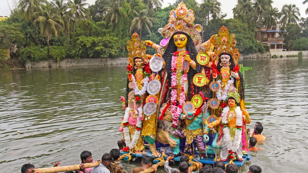 Devotees immerse an idol of Goddess Durga at the end of the Durga Puja festival celebrations at Bolpur in Birbhum district, West Bengal