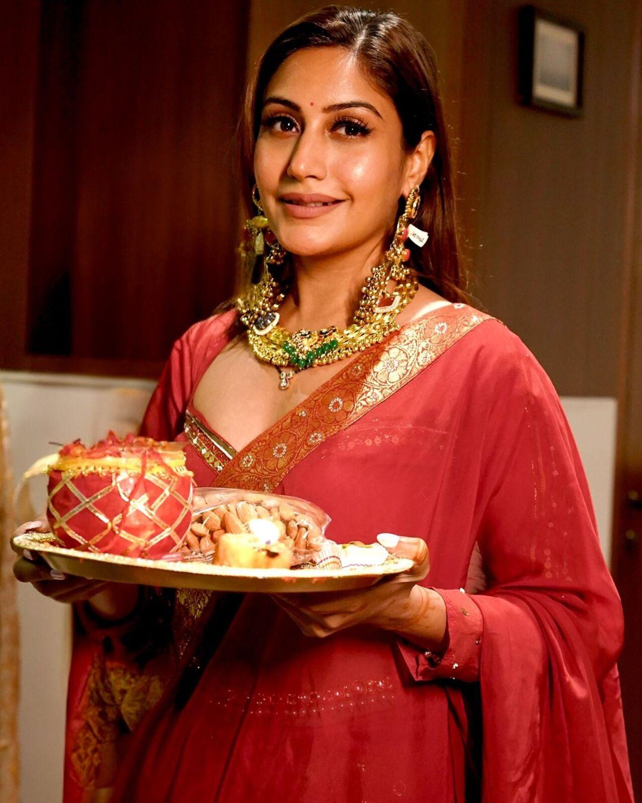 Surbhi shared pictures clad in a bespoke red saree as she prepared for the festivities. 