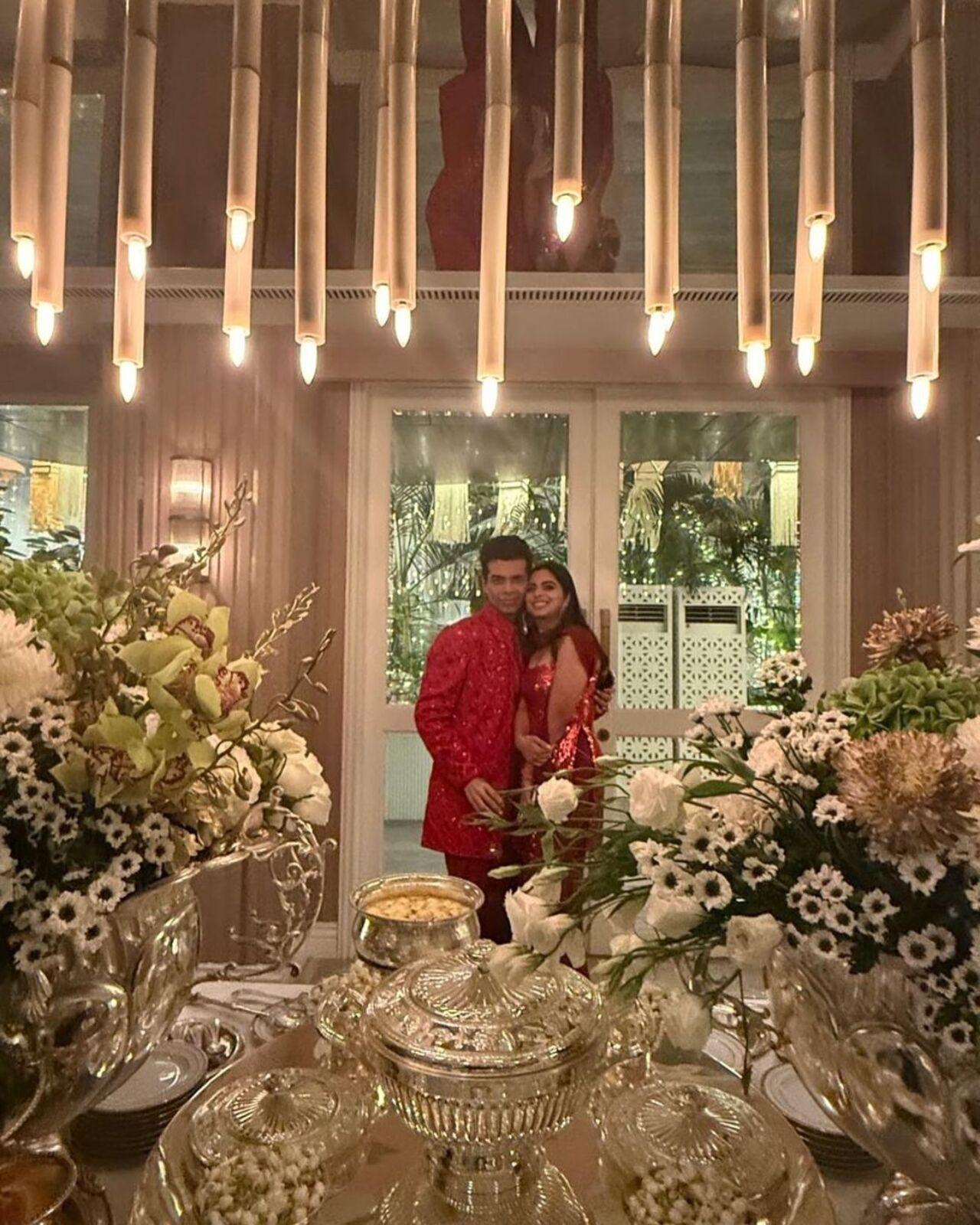 Karan Johar poses with Isha Ambani in the background of Manish's extravagant and classy party decor