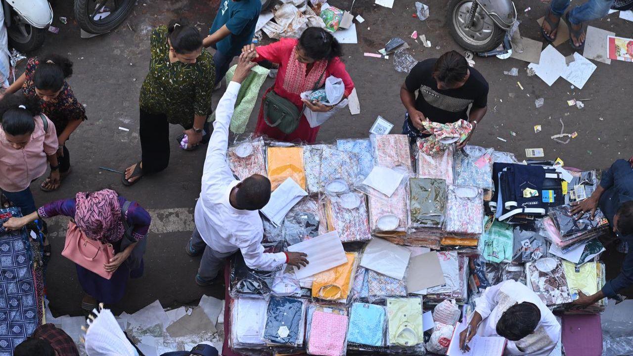 Shoppers flock to cloth stalls to buy new traditional outfits, as wearing new clothes during Diwali signifies renewal and positivity