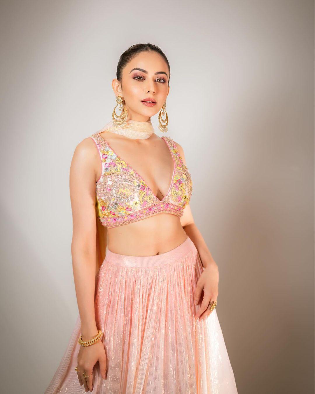 In this look, Rakul wore a beautiful pink lehenga that has pastel yellow at the bottom and paired it with an embroidered blouse and matching dupatta.