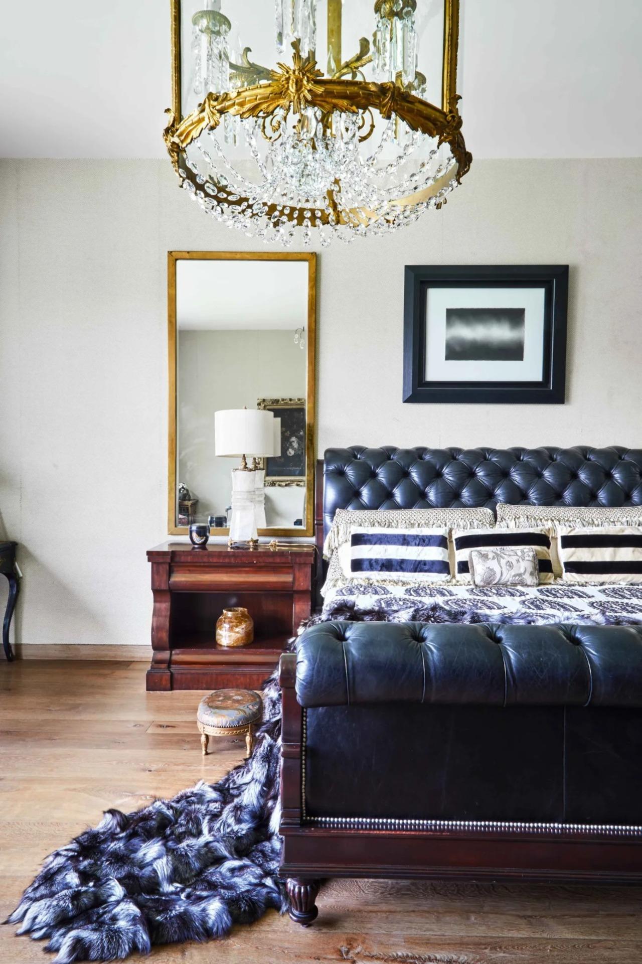 In the bedroom, above the Ralph Lauren Clivedon' tufted bed is an Anish Kapoor. The gilt bronze chandelier is late-18th-century French; the lamp on the bedside table is solid rock crystal; and the candleholder in the shelf beneath it is from Soane Britain