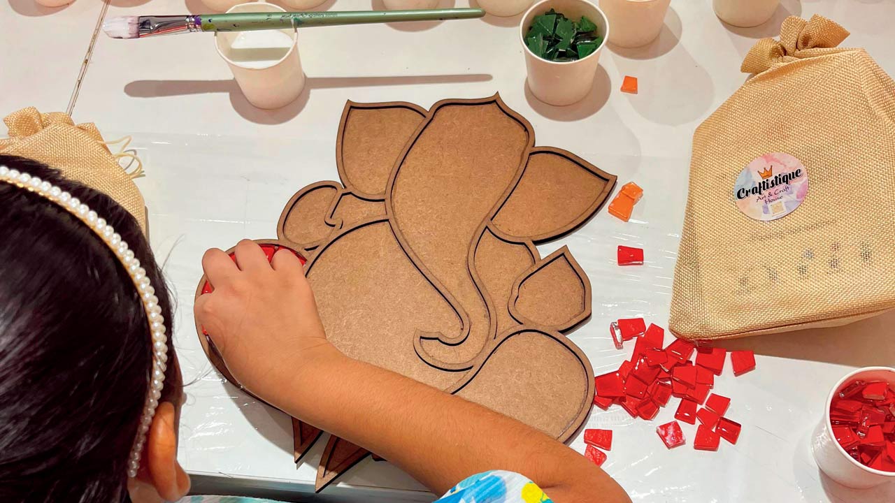 A child works on a mosaic of Ganesha at a previous edition