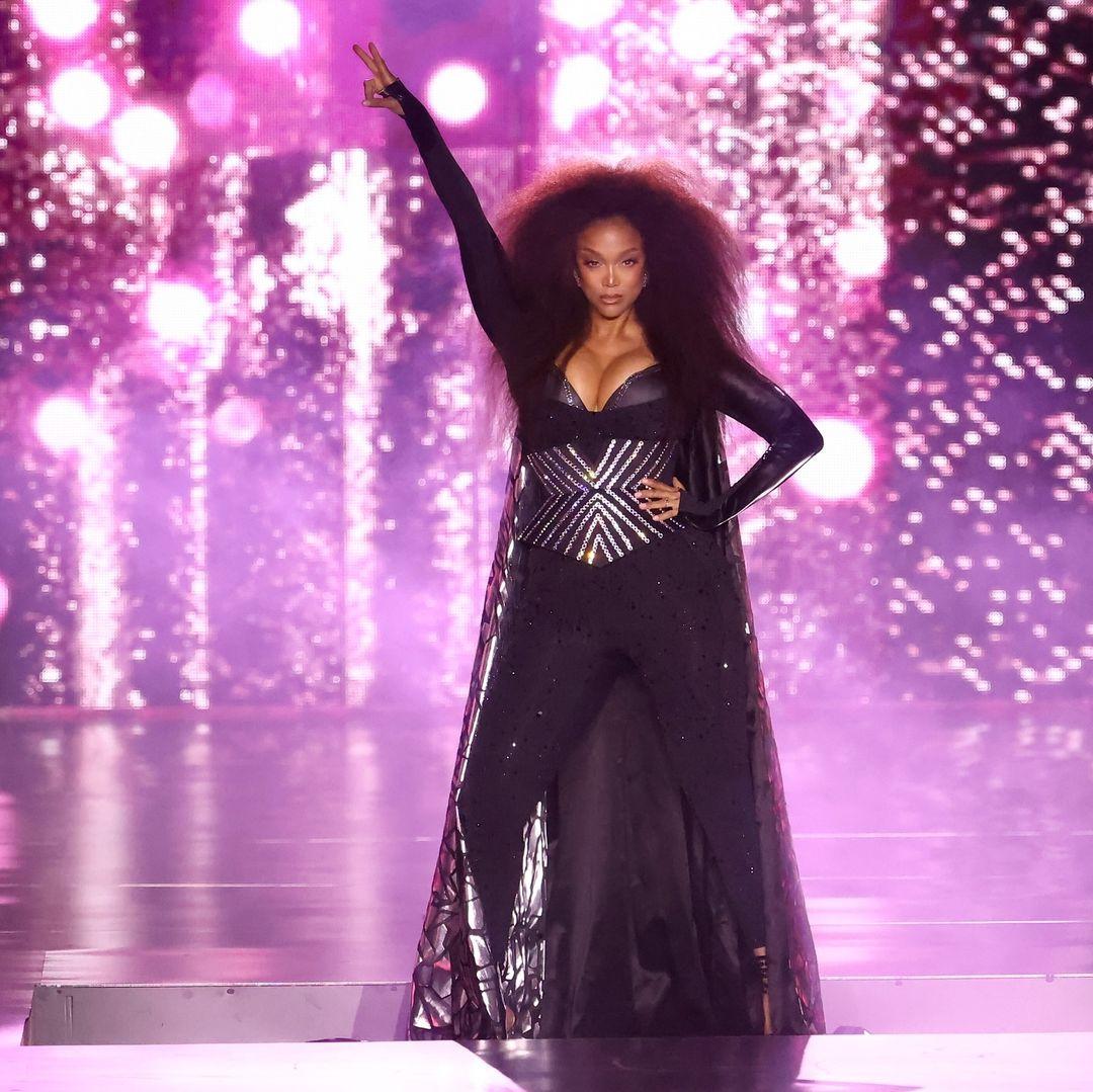 She made a statement on the runway, wearing a silver cape with black lining, a crystal-covered bustier, glittery leggings, and heels.