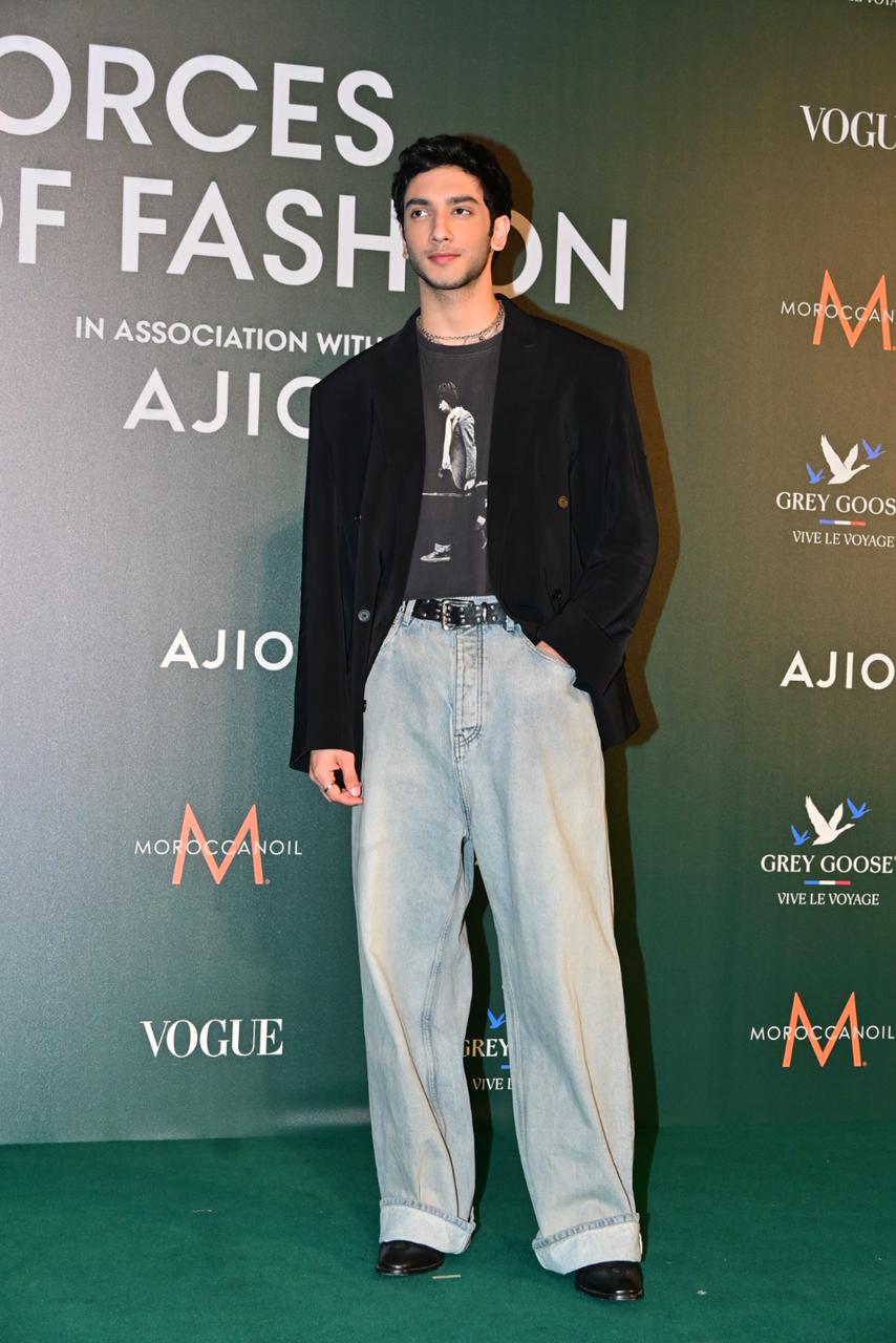 He completed the outfit with a black blazer, Chelsea boots, a silver choker, and styled his hair swept back.