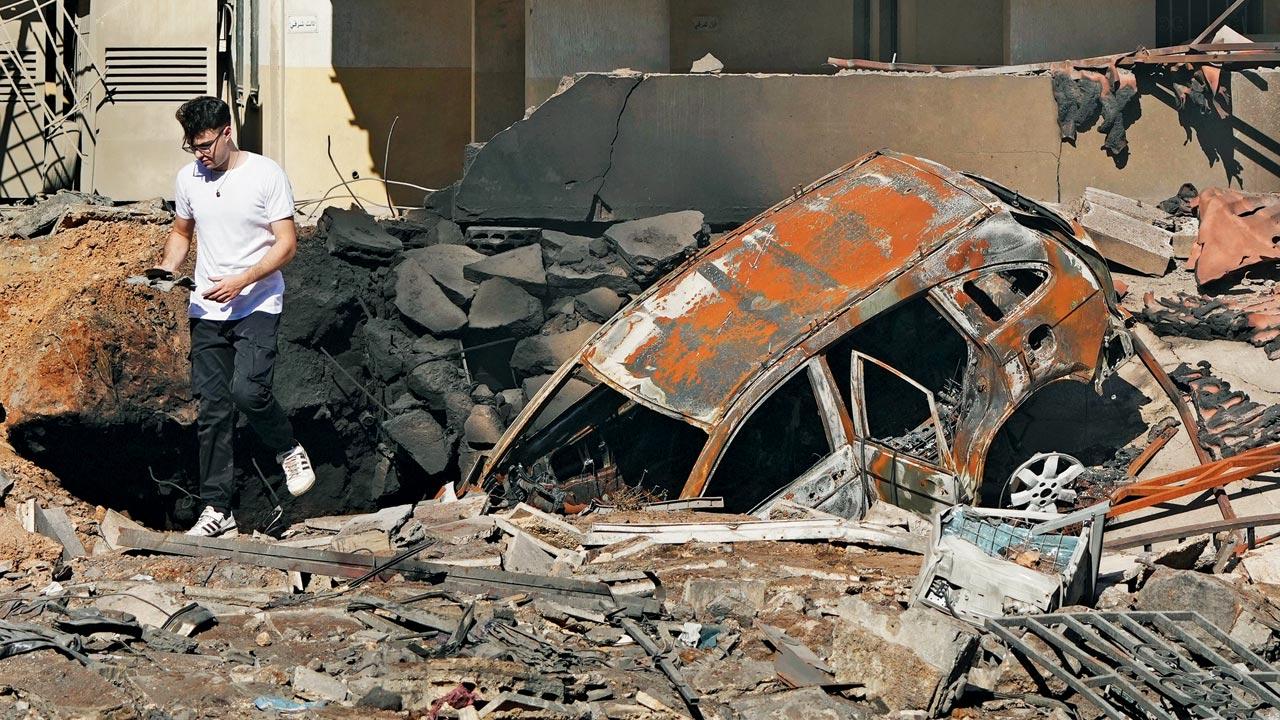 A man walks past the destruction caused by an Israeli airstrike in Beirut