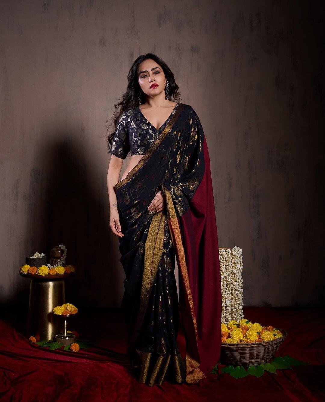 Oh Lord! This has to be the best look of all. Amruta, in this look, wore a beautiful dark blue saree with golden motifs printed on it