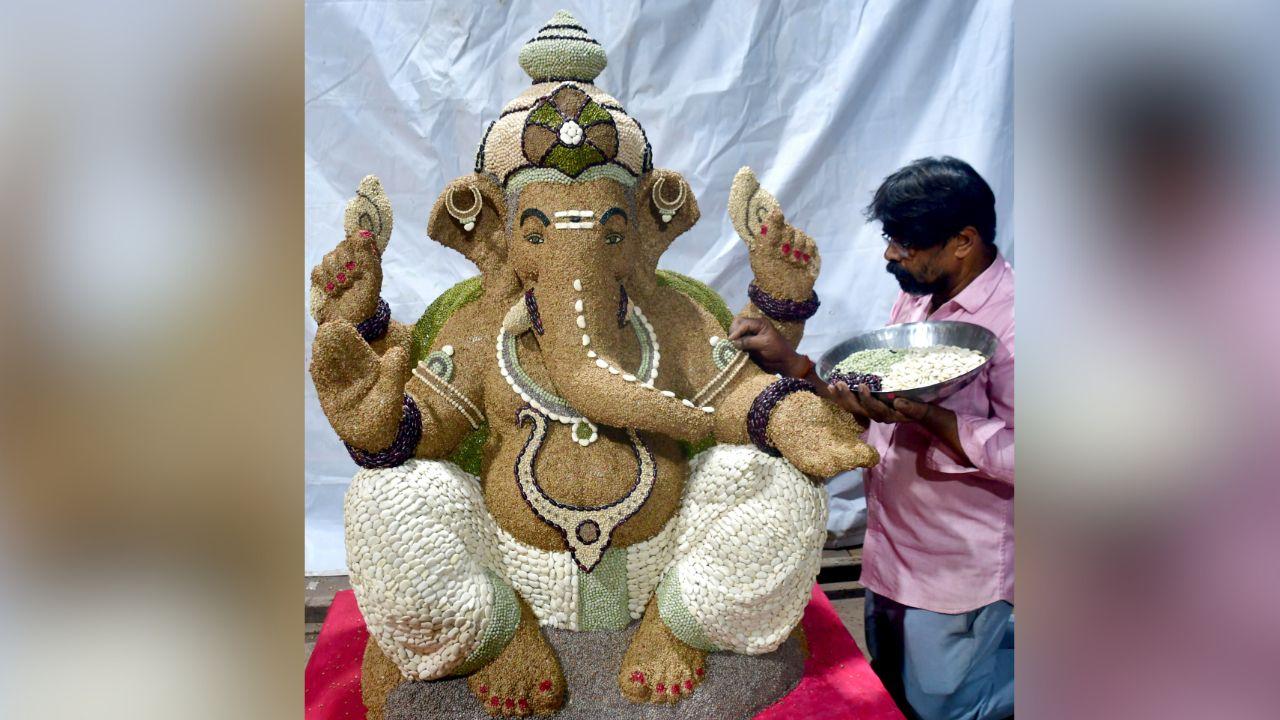 An artist gives the final touch to the idols of Lord Ganesha made up of pulses for the upcoming Ganesh Chaturthi Festival, in Mumbai.