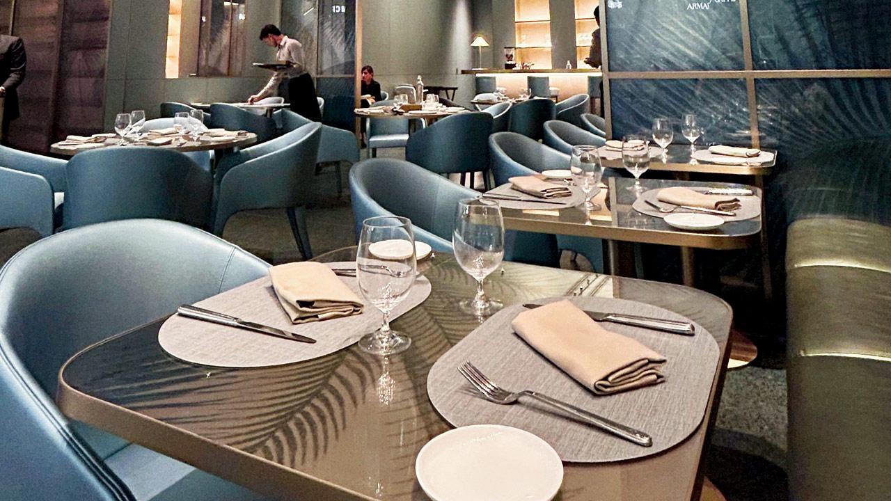 The upscale eatery adjacent to the Giorgio Armani store reveals teal-green interiors with sleek gold accents through its glass facade