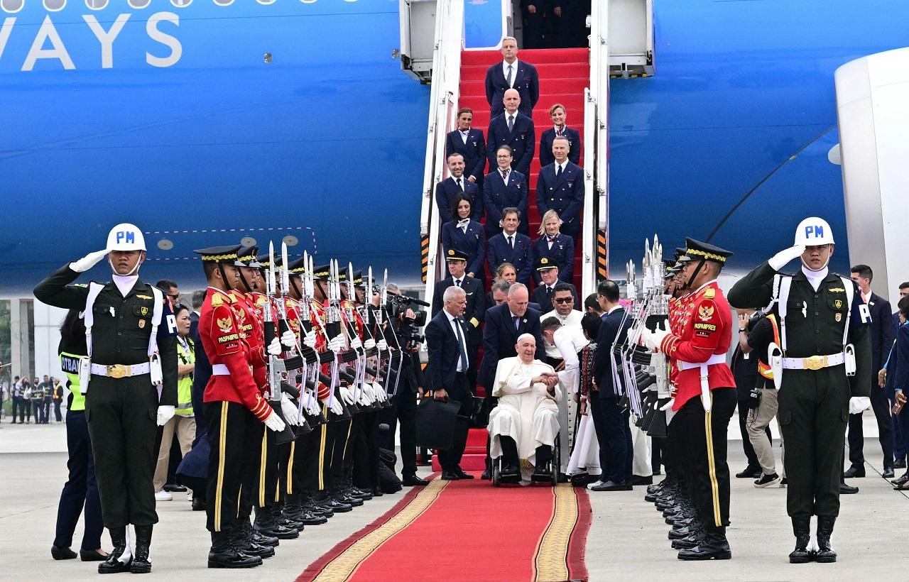 Sitting in a wheelchair, Francis disembarked from the plane via a lift and was handed a bouquet of local produce by two children dressed in traditional attire, the Indonesian news publication reported
