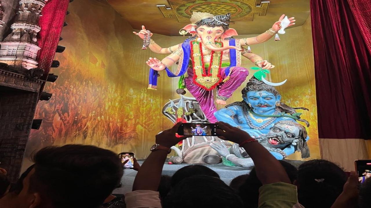 Devotees take pictures of their favourite deity as the Mumbaicha Raja idol is unveiled in Parel on Thursday