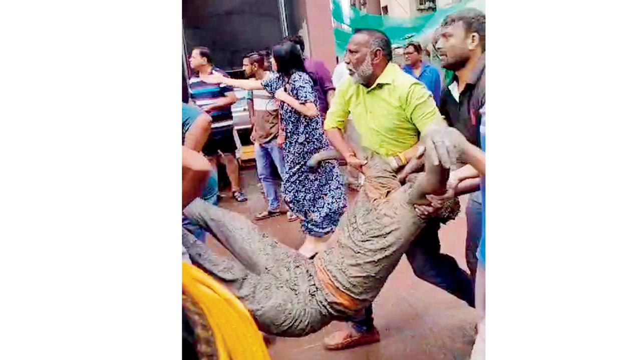 Society members and locals carry one of the injured labourers