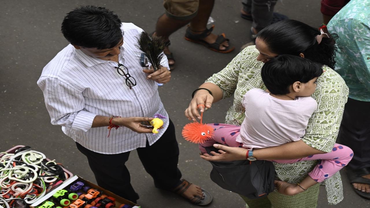 Parents buy toys for their kids to keep them occupied while shopping in a busy market at Dadar West of Mumbai