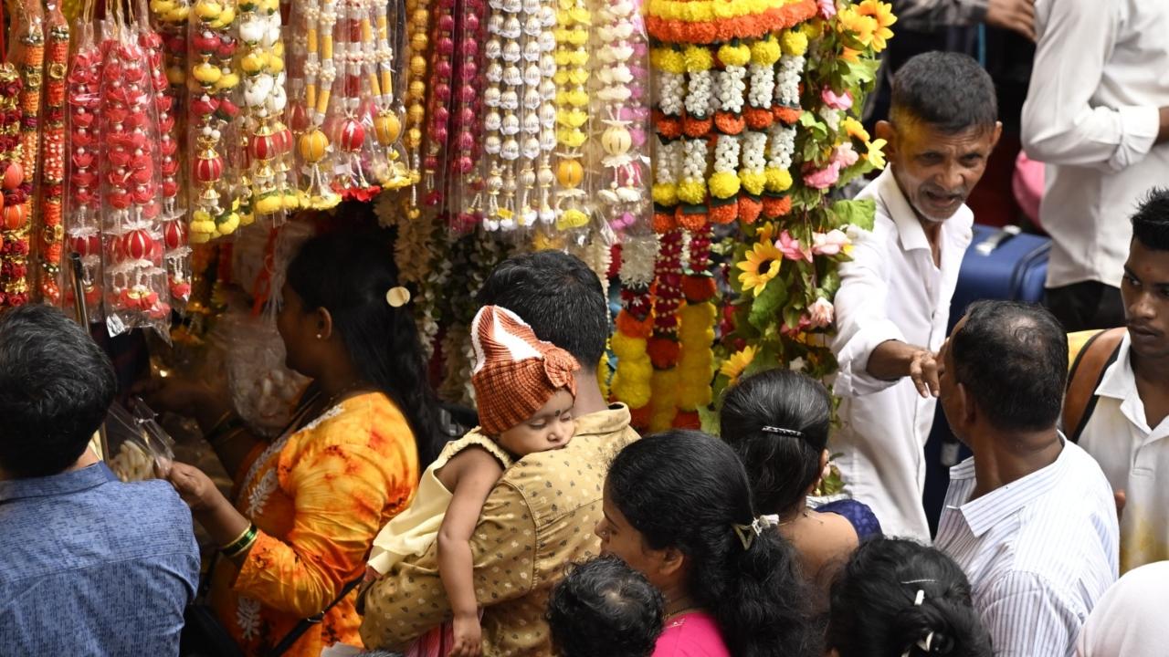 Nap time: A child doses off in its father's arms at a crowded shop in Dadar  