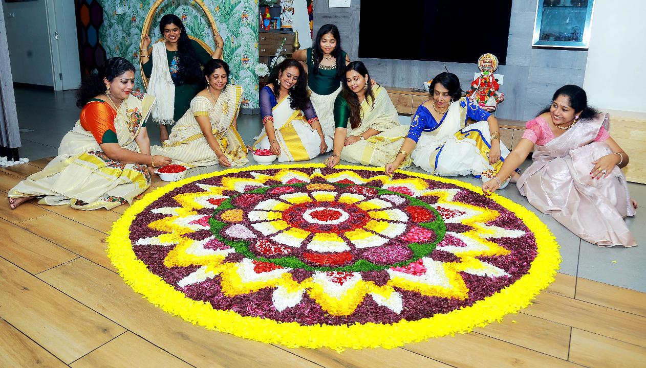 Malayali community members decorate 'Pookalam', a rangoli made with fresh flowers, as part of the Onam festival celebrations, in Bengaluru.