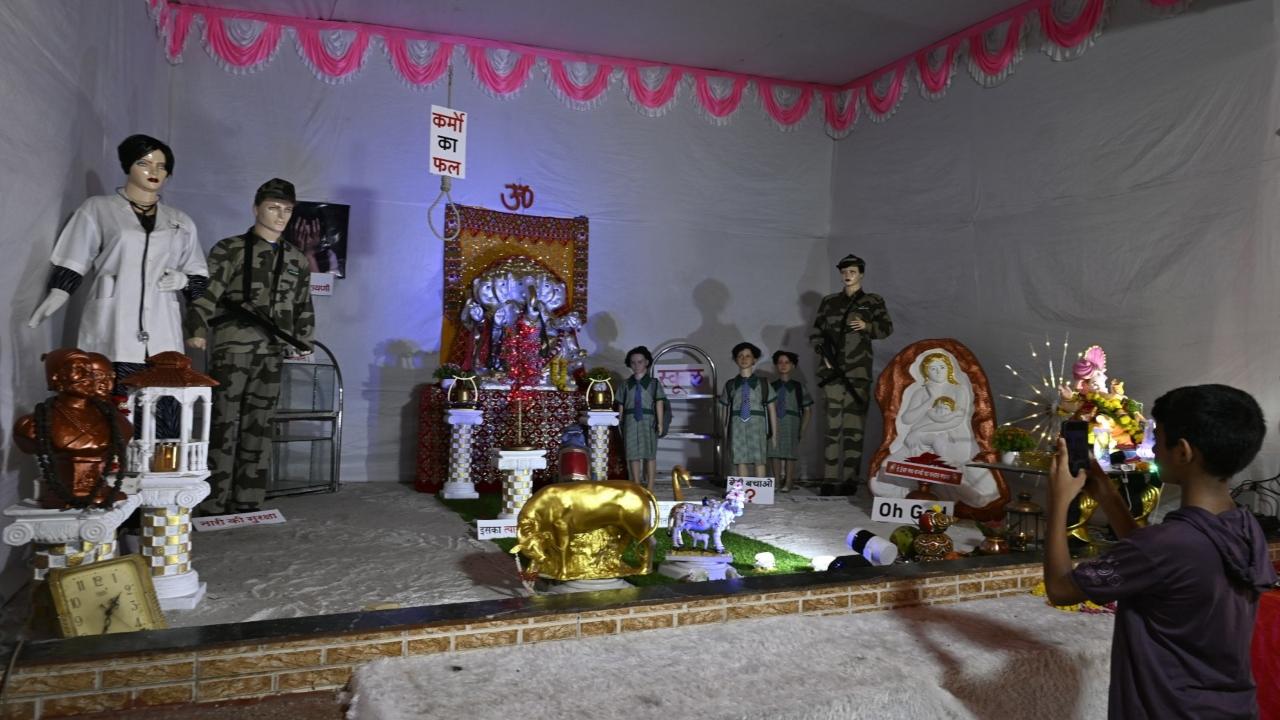 A young devotee clicks pictures of the Ganpati pandal