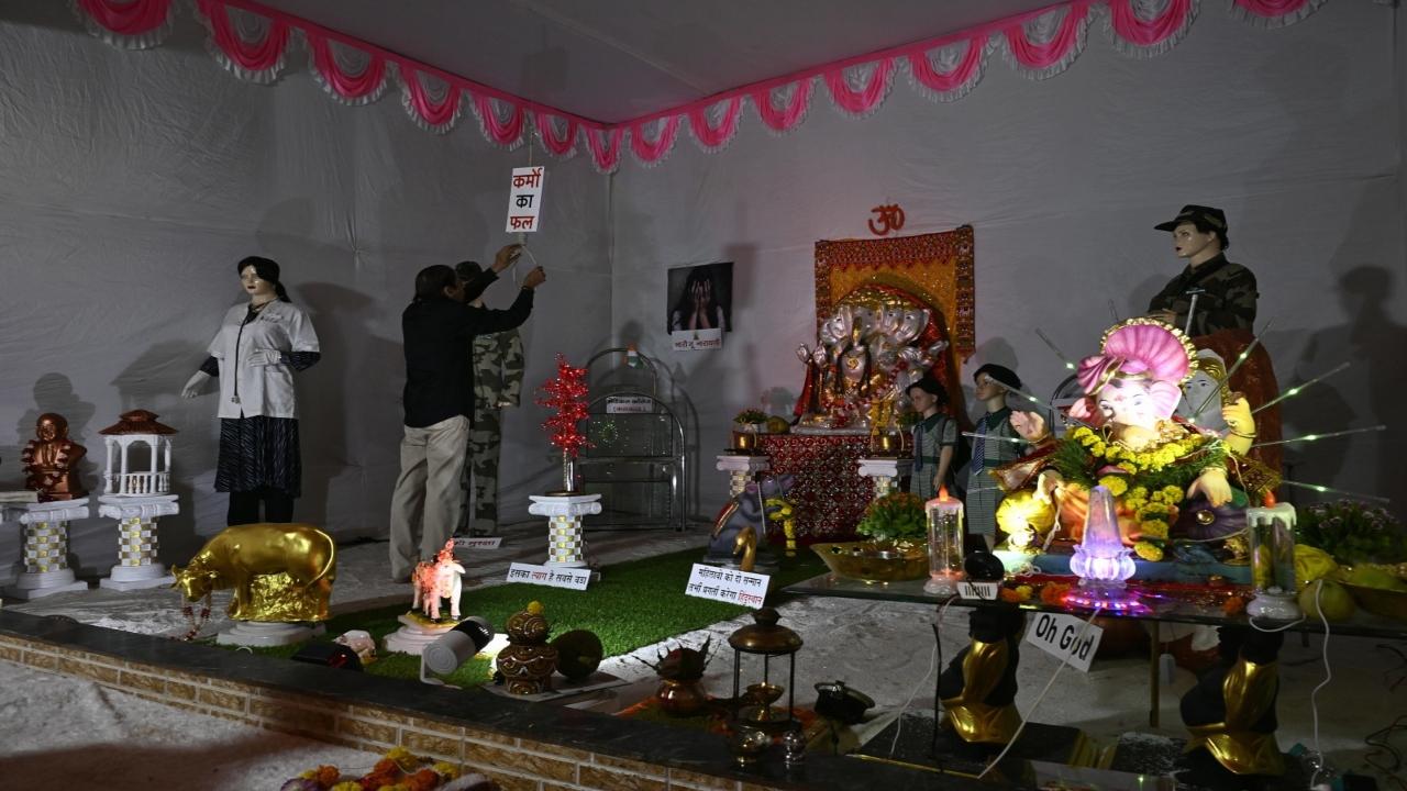 A mandal member adjusts a noose kept at the pandal to emphasise on the importance of death penalty for cases of sexual crimes against women and children