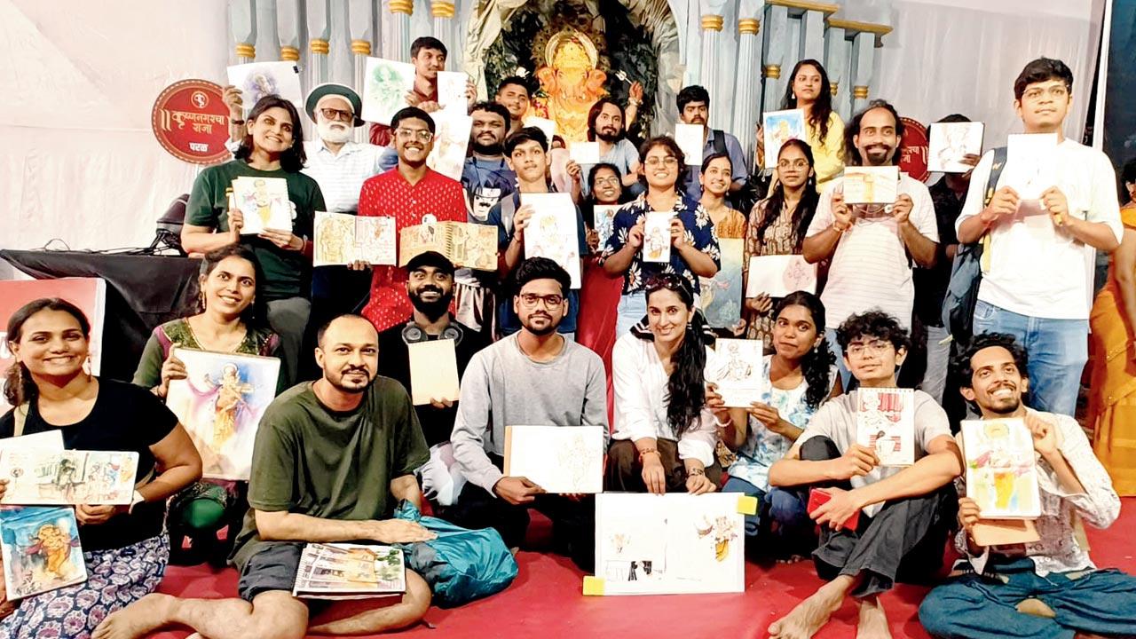Participants hold up their sketches before the Ganesh idol at the pandal