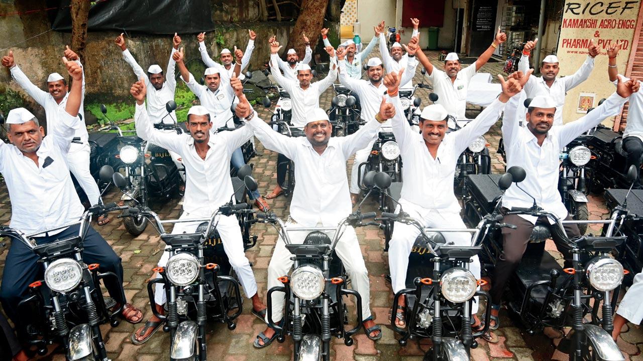Mumbai dabbawalas with their electric bikes at the event