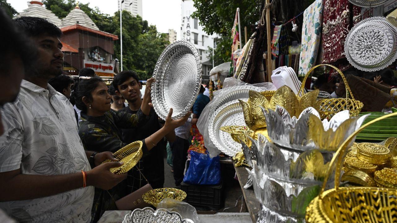 People were seen shopping for various items needed for the festival, including decorations, offerings, and pooja essentials. 