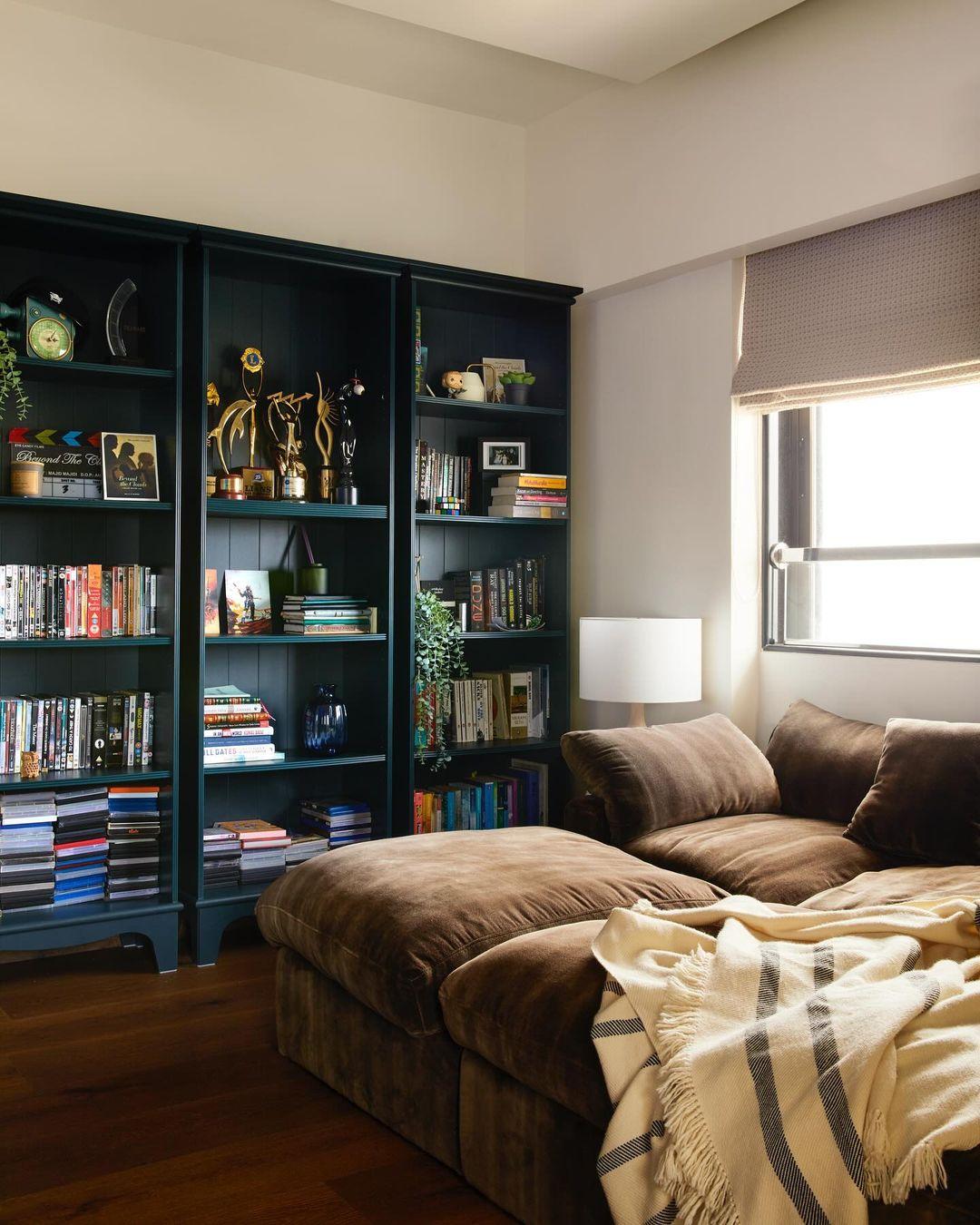 The blue-coloured bookshelf adds a quirky yet tasteful touch, serving as a unique design piece that sets the tone for the rest of the home.
