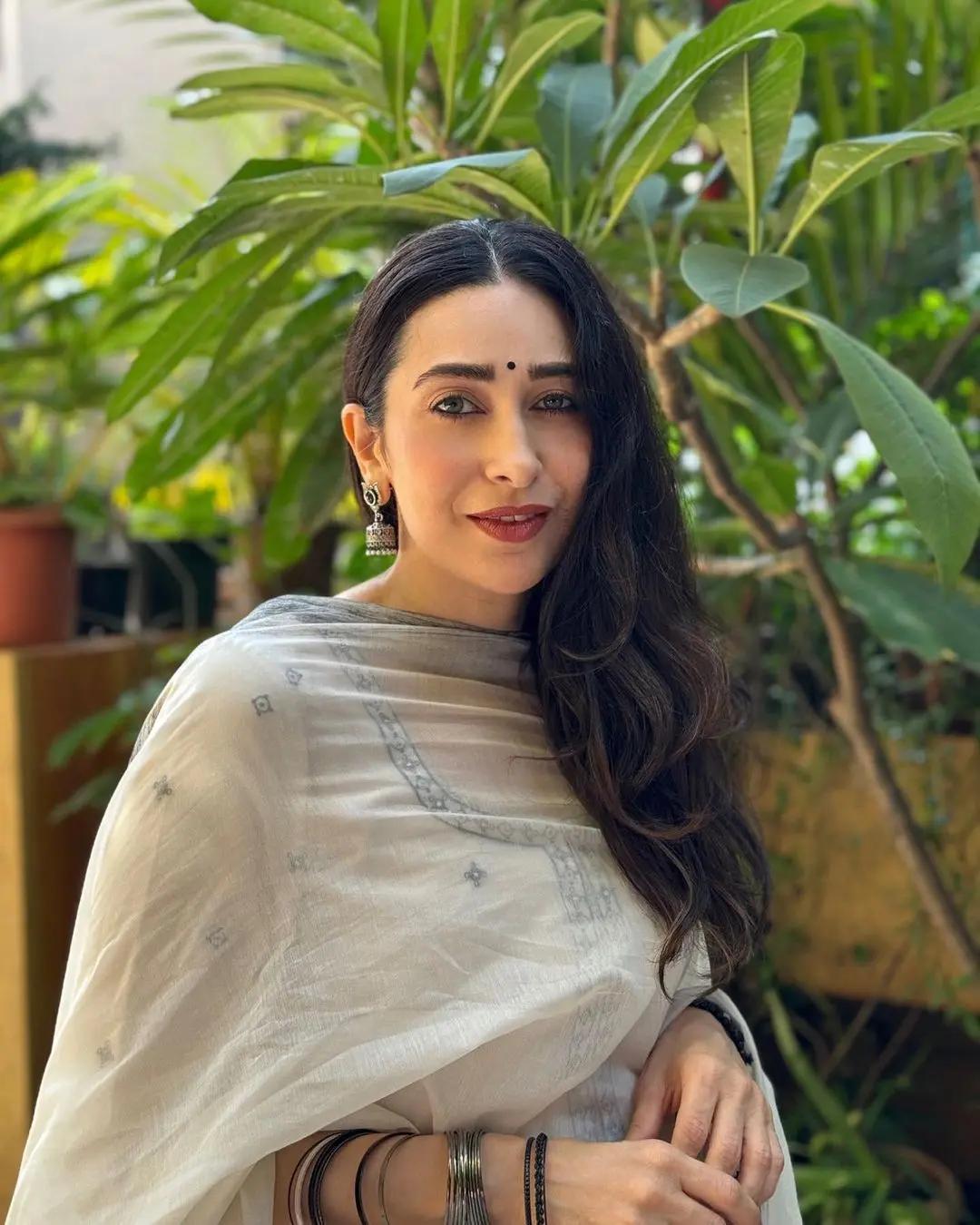 The intricate embroidery adds a touch of timeless beauty, capturing the festive spirit beautifully. Karisma's simple yet stylish accessories complete the look, making it the ideal choice to celebrate Sastami.