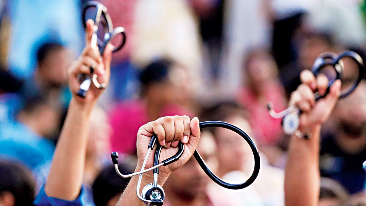 Doctors hold up stethoscopes and shout slogans in Kolkata