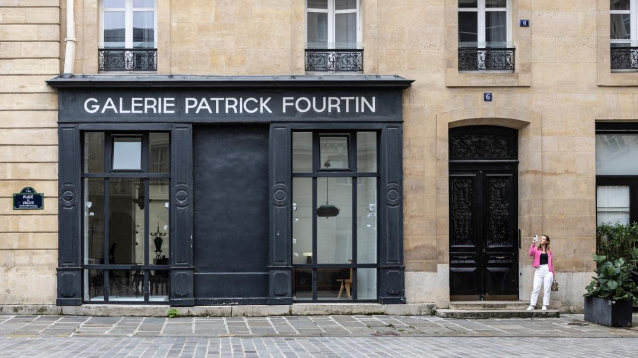 A woman takes a selfie on Place Valois, one of the many iconic Paris locations to feature in 'Emily in Paris'