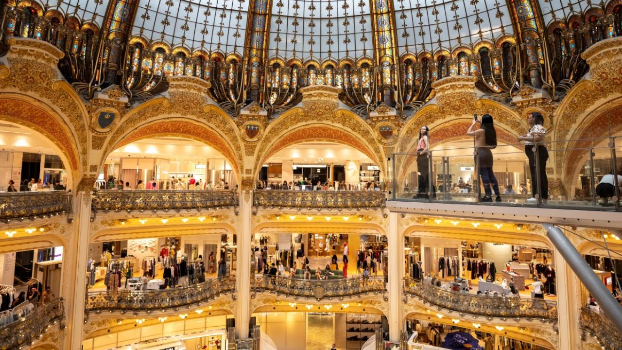 Visitors pose for photographs in Galeries Lafayette