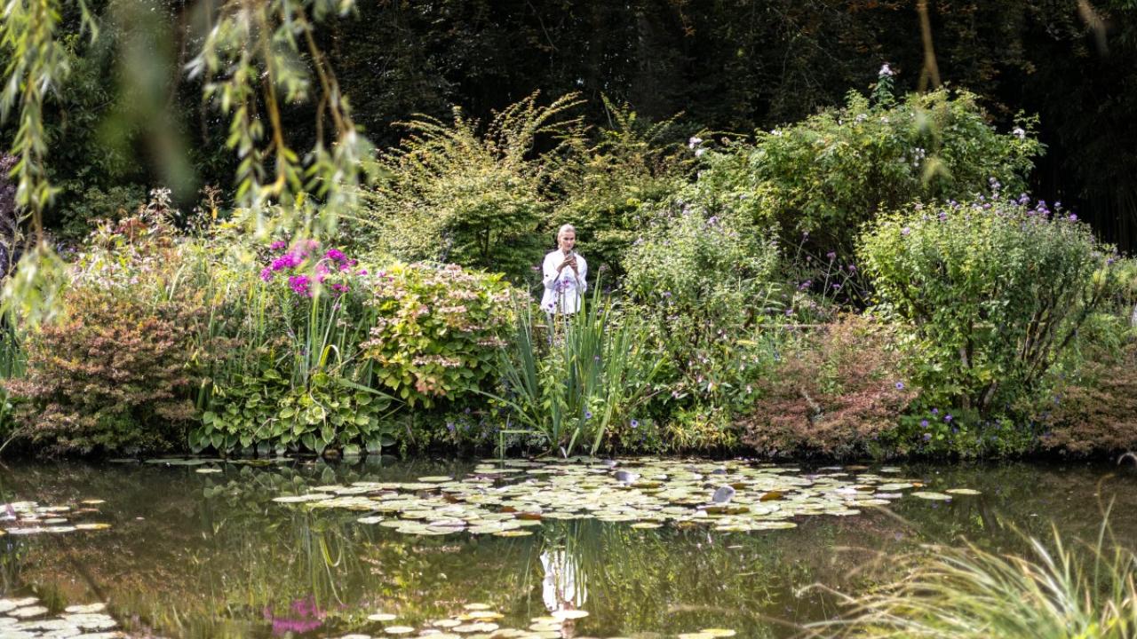 A woman takes a photo of Nympheas in the French Impressionist painter Claude Monet's gardens (Jardins de Claude Monet) in Giverny. Although not in Paris, this is one of the most famous locations featured in the show. 