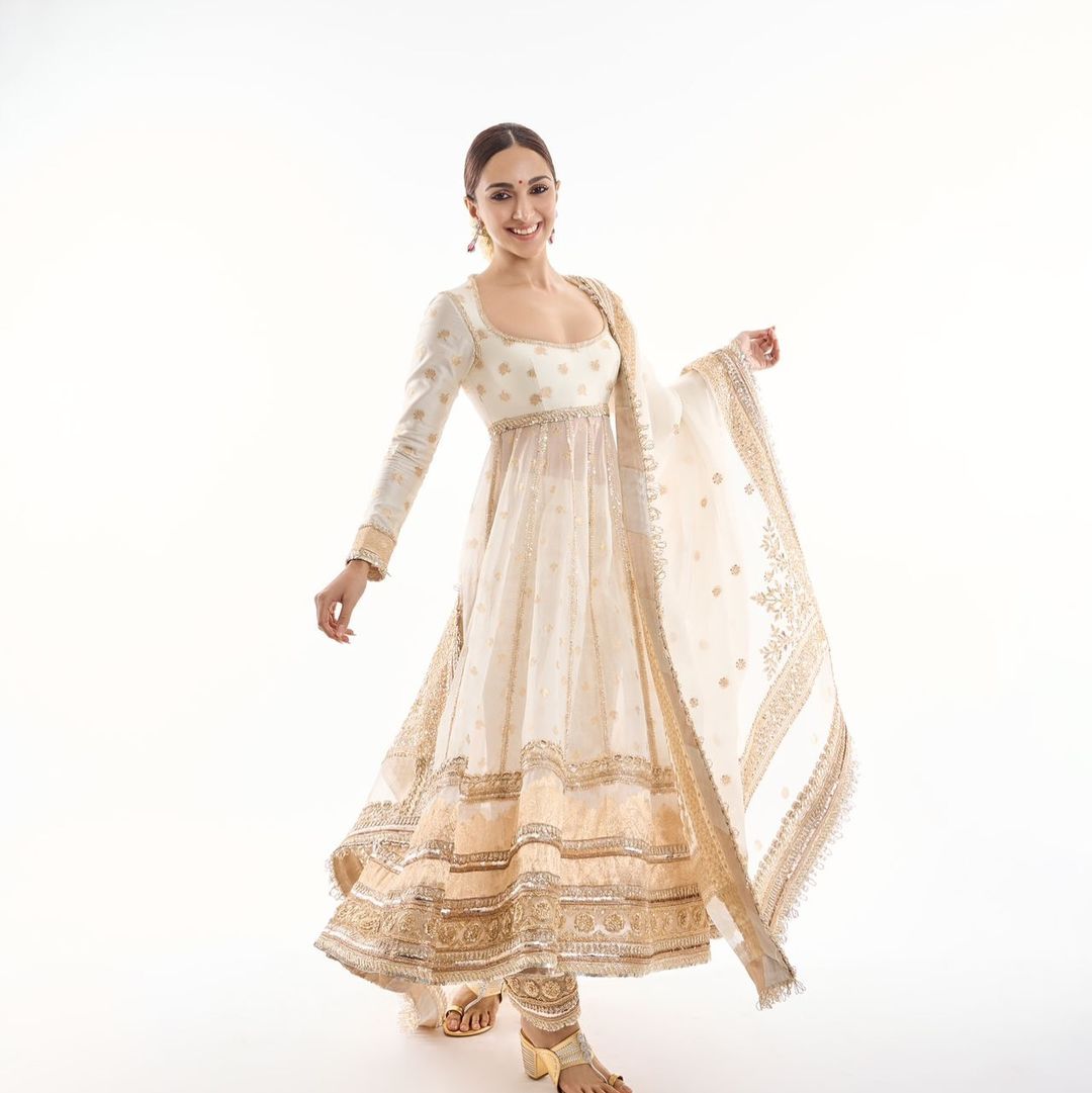 Kiara Advani wore a classic off-white and gold handloom Banarasi woven silk and tissue organza saree with intricate zari work. The actress further elevated her look with perfectly matching, elegant earrings from Manish Malhotra