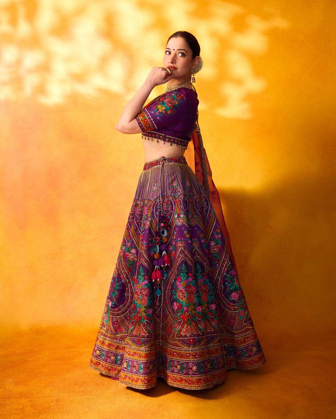 Tamannaah Bhatia wore a gorgeous purple lehenga with intricate embroidery. She chose a Karan Torani outfit and kept her hair and makeup basic. The actress tied her hair in a chic bun decorated with gajra with minimal makeup