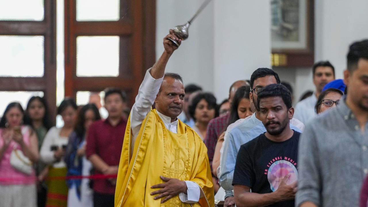 A priest sprinkles holy water on people as they offer prayers at Sacred Heart Cathedral Church in New Delhi
Special rituals are also performed in churches in observance of the occasion.