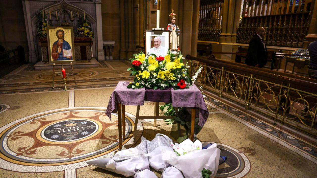 People placed flowers in front of a portrait of the late Pope Francis on display inside St Mary's Cathedral in Sydney