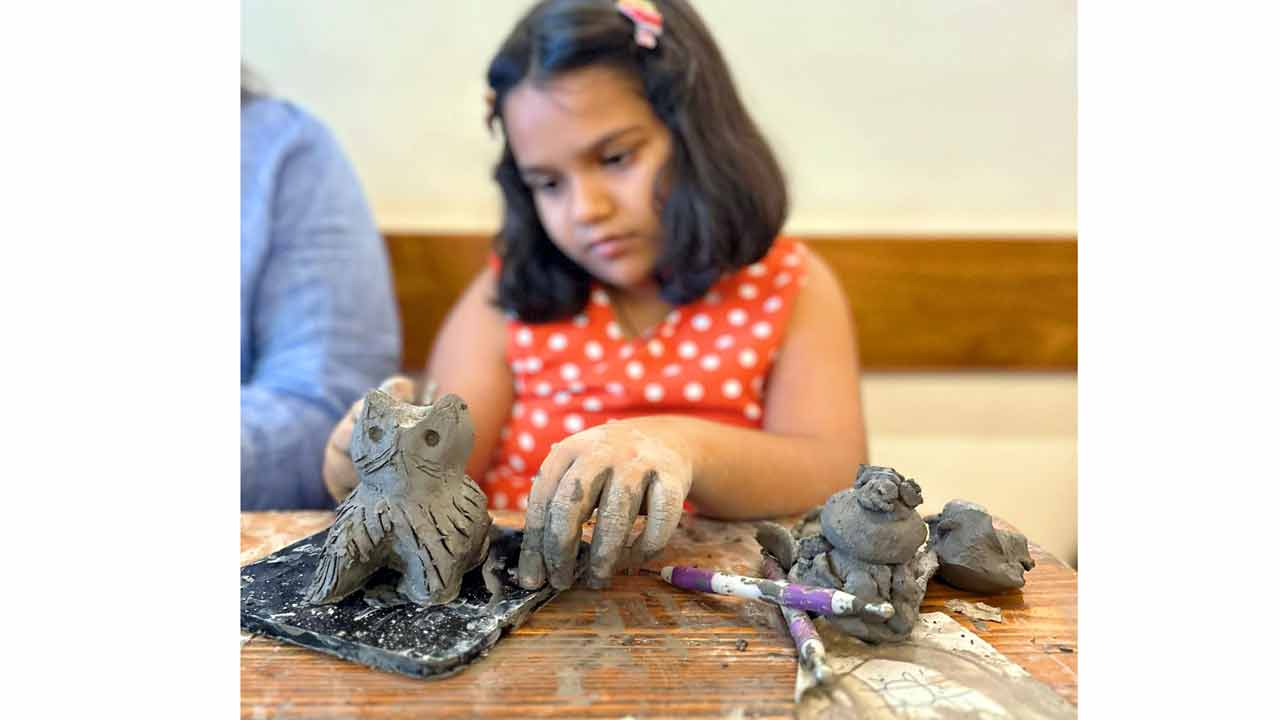 (From left) A child adds finishing touches to a sculpture; an adult participant works with clay. PICS COURTESY/GARIMA SHARMA