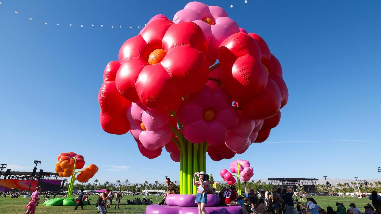 Festival goers pose under French design collective Uchronia's 