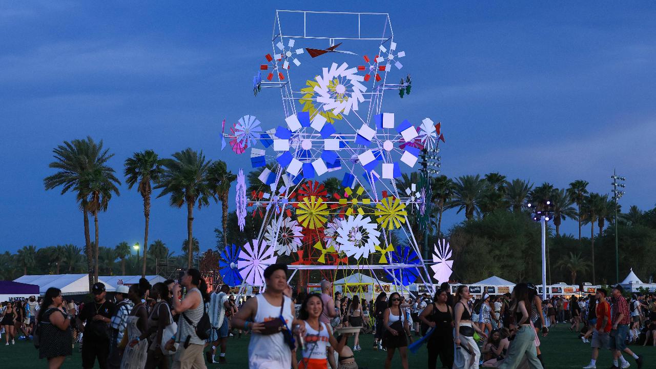 Festival goers walk by Isabel + Helen's 