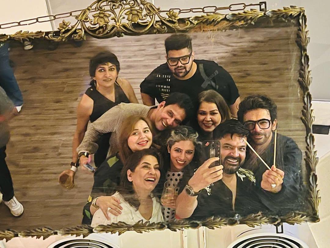 In this picture, Kapil is seen clicking a mirror selfie while posing with Sunil Grover, Archana Puran Singh, and Ginni