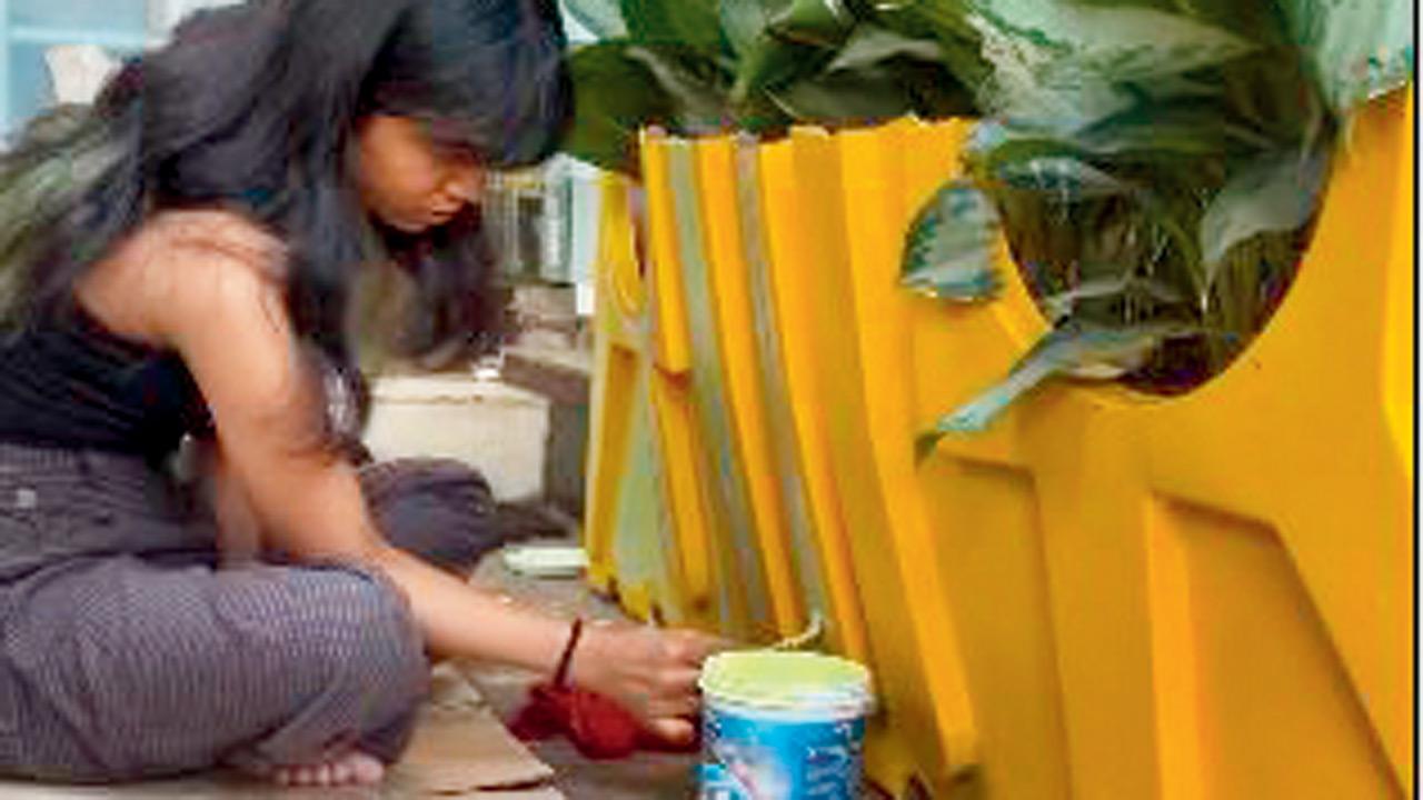 A team member paints the planter.  PIC COURTESY/GRACIAS GRANNY