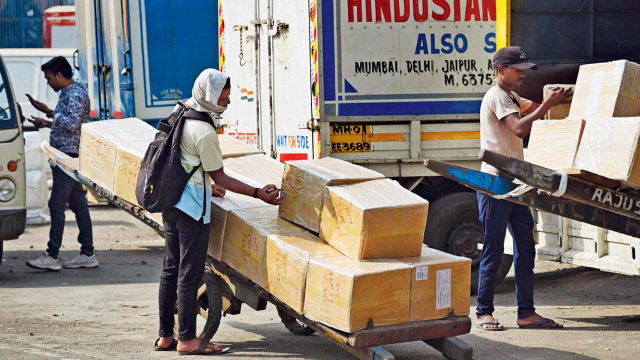 A porter hauls luggage outside the parcel section at Bandra Terminus under the afternoon sun. Pic/Ashish Raje